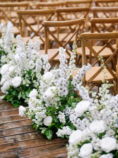 rows of wooden chairs with white flowers on them