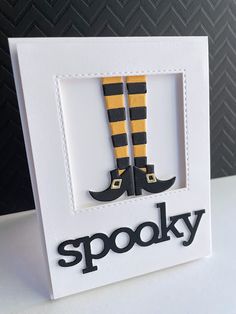 a white card with black and yellow striped socks on it that says spooky