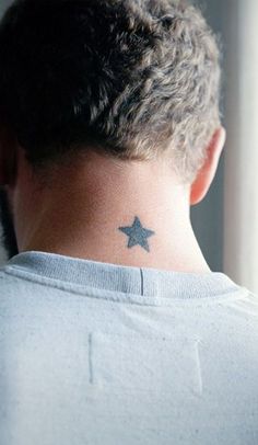 the back of a man's neck with a star tattoo on his left side