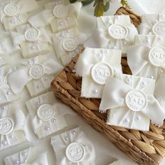 several pieces of white fabric sitting on top of a basket next to flowers and pearls