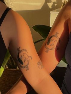 two people with tattoos on their arms