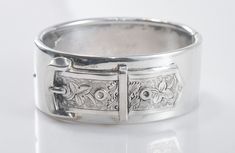 Wide sterling silver bangle bracelet is unmarked and tests as sterling silver, and appears to be handmade.  It features an applied floral buckle and a rolled edge.  It has a width of 1 full inch and an inside circumference of about 6 1/2 inches, so this is a small wrist bracelet.  It is heavy, weighing 61.1 grams.  The bracelet opens with a manual push/pull and clicks closed by sliding the button into the groove.  It closes tight, but both ends must be manually lined up. Silver Buckle Bracelet, Wrist Bracelet, Large Bracelet, Silver Bangle Bracelet, Sterling Silver Bangle Bracelets, Sterling Silver Bangle, Silver Bangle Bracelets, Sterling Silver Bangles, Silver Bangle