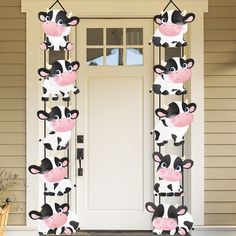 the door is decorated with farm animals on it's front porch, and there are two poles that have been cut out to look like cows