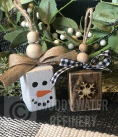 a wooden block with a snowman ornament hanging from it's side