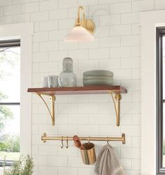 a kitchen counter with pots and pans hanging on the wall next to a window