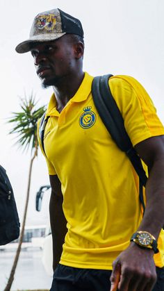 a man wearing a yellow shirt and black shorts