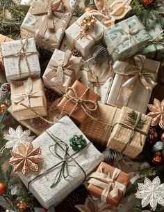 many presents are wrapped in brown paper and tied with twine bowes, pine cones, and bows