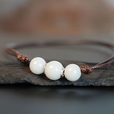 "Breastmilk pearl beaded bracelet with 1mm brown waxed cord.  Our  Simple Pearl Beads Bracelet is a pure and simple celebration of the natural beauty of motherhood. Sterling silver core in the central bead (rose or yellow gold options available). Add pearl powder for lustrous effect.  For all our breast milk bracelet collection, please visit: https://www.etsy.com/ca/shop/KeepsakeMom?ref=seller-platform-mcnav&section_id=27169694 For all breastmilk jewelry, please visit:  https://www.etsy.com/ca/s Breast Milk Jewelry Bracelet, Pearl Beaded Bracelet, Breastmilk Jewelry, Silver Core, Simple Pearl, Pearl Powder, Jewelry Pearl, Bracelet Collection, Beads Bracelet