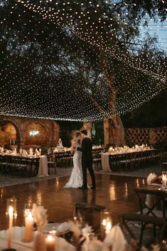 a bride and groom standing in the middle of a dance floor at their wedding reception