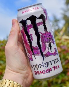 a person holding up a can of monster tea