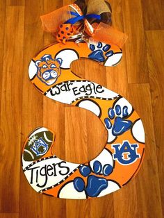 the letter s is decorated with orange and blue paw prints