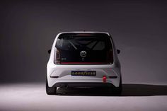 the rear end of a white volkswagen e - trac parked in a dark room