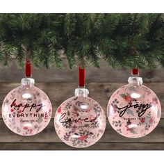 three christmas ornaments hanging from a tree with the words happy everything written on one ornament