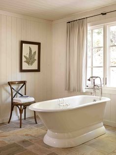 a white bath tub sitting next to a window