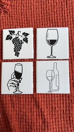 four coasters with black and white images of wine glasses, grapes and a bottle