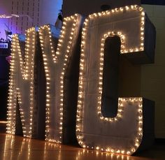 lighted letters spelling the word joy in front of a wall