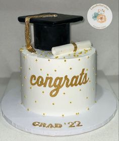 a graduation cake with gold confetti and congratulations written on the side, along with a mortar cap