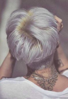 the back of a woman's head with grey hair and tattoos on her neck