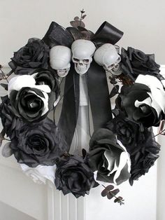 a wreath with skulls and black roses on the front door, decorated with fake flowers