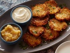 potato cakes with sour cream and butter on a white plate next to two small bowls