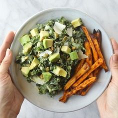 two hands holding a white plate with some food on it