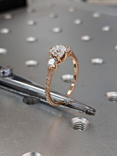 a diamond ring sitting on top of a piece of metal