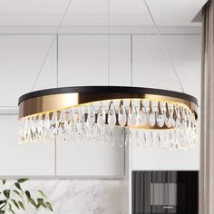 a chandelier hanging from the ceiling in a modern kitchen with marble countertops