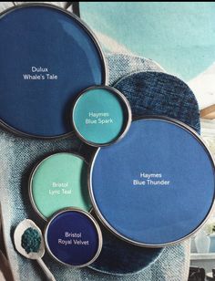 four different shades of blue paint sitting on top of each other with spoons in front of them