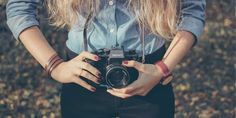 a woman holding a camera in her hands