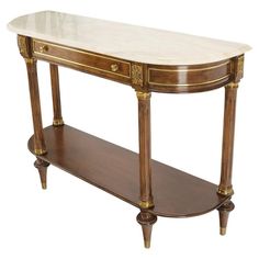 an antique console table with marble top and gold trimmings on the bottom shelf