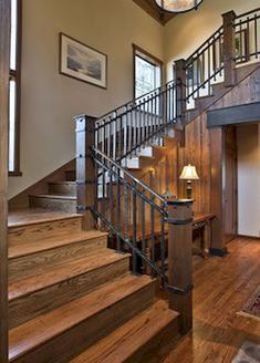 a wooden staircase with metal handrails and chandelier