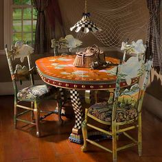 a dining room table with chairs and a lamp hanging from it's center point