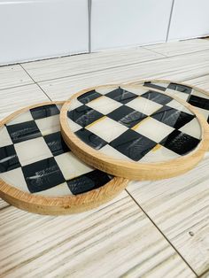 two black and white checkered plates sitting on top of a wooden floor