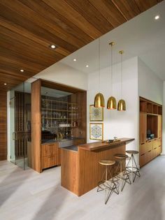 a kitchen with wooden cabinets and bar stools