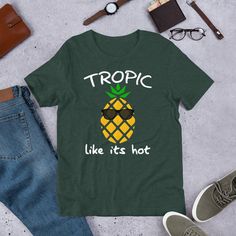 "Tropic Like It's Hot - Tropical Pineapple Short-Sleeve Unisex T-Shirt This t-shirt is everything you've dreamed of and more. It feels soft and lightweight, with the right amount of stretch. It's comfortable and flattering for both men and women.  * 100% combed and ring-spun cotton (heather colors contain polyester) * Fabric weight: 4.2 oz (142 g/m2) * Shoulder-to-shoulder taping * Side-seamed The Male model is wearing a size M. He's 6.2 feet (190 cm) tall, chest circumference 37.7\" (96 cm), waist circumference 33.4\" (85 cm). The female model is wearing a size M. She's 5.8 feet (178 cm) tall, chest circumference 34.6\" (88 cm), waist circumference 27.16\" (69 cm), hip circumference 37.7\" (96cm)." Tall Chest, It's Hot, Shoulder Taping, Male Model, Unisex T Shirt, Fabric Weights, Spun Cotton, Polyester Fabric, Adult Outfits