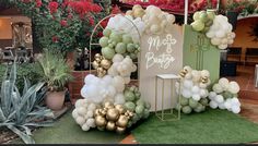 an outdoor display with balloons and flowers in the shape of a heart, surrounded by succulents