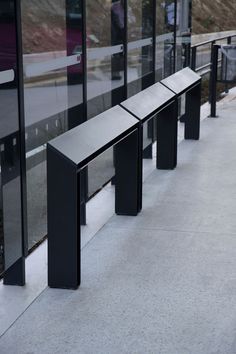 a row of black metal benches sitting next to each other