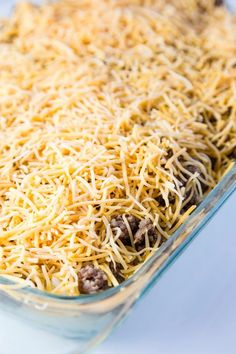 a casserole dish filled with cheese and ground beef in a glass baking dish