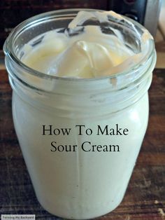 a jar filled with sour cream sitting on top of a wooden table