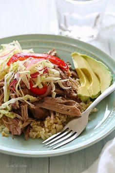 a blue plate topped with meat, rice and avocado next to a fork