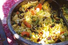 a bowl filled with rice and vegetables on top of a table