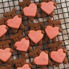 some heart shaped cookies are on a cooling rack with teddy bears and hearts in the middle