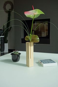 a flower in a wooden vase on a table