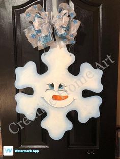 a snowflake door hanger with a bow on it's head and eyes