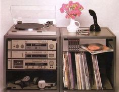 an old record player is sitting on top of a shelf with records and cassettes