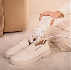 a woman is tying up her shoes with white laces on the bottom and sides