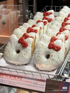 donuts with white frosting and sprinkles are on display in a store