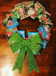 a wreath made out of candy bars and green glitter ribbon on top of a wooden table