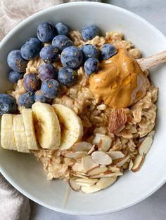 an oatmeal bowl with blueberries, bananas and peanut butter on top