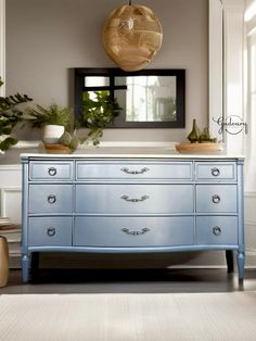 a blue dresser sitting in front of a mirror